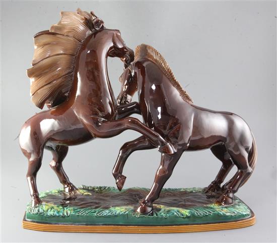 R. Prunet. A tin glazed terracotta group of two mustangs, width 22in. height 19in.